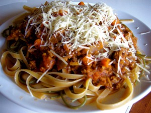 spaghetti, meat sauce and some parmesan cheese